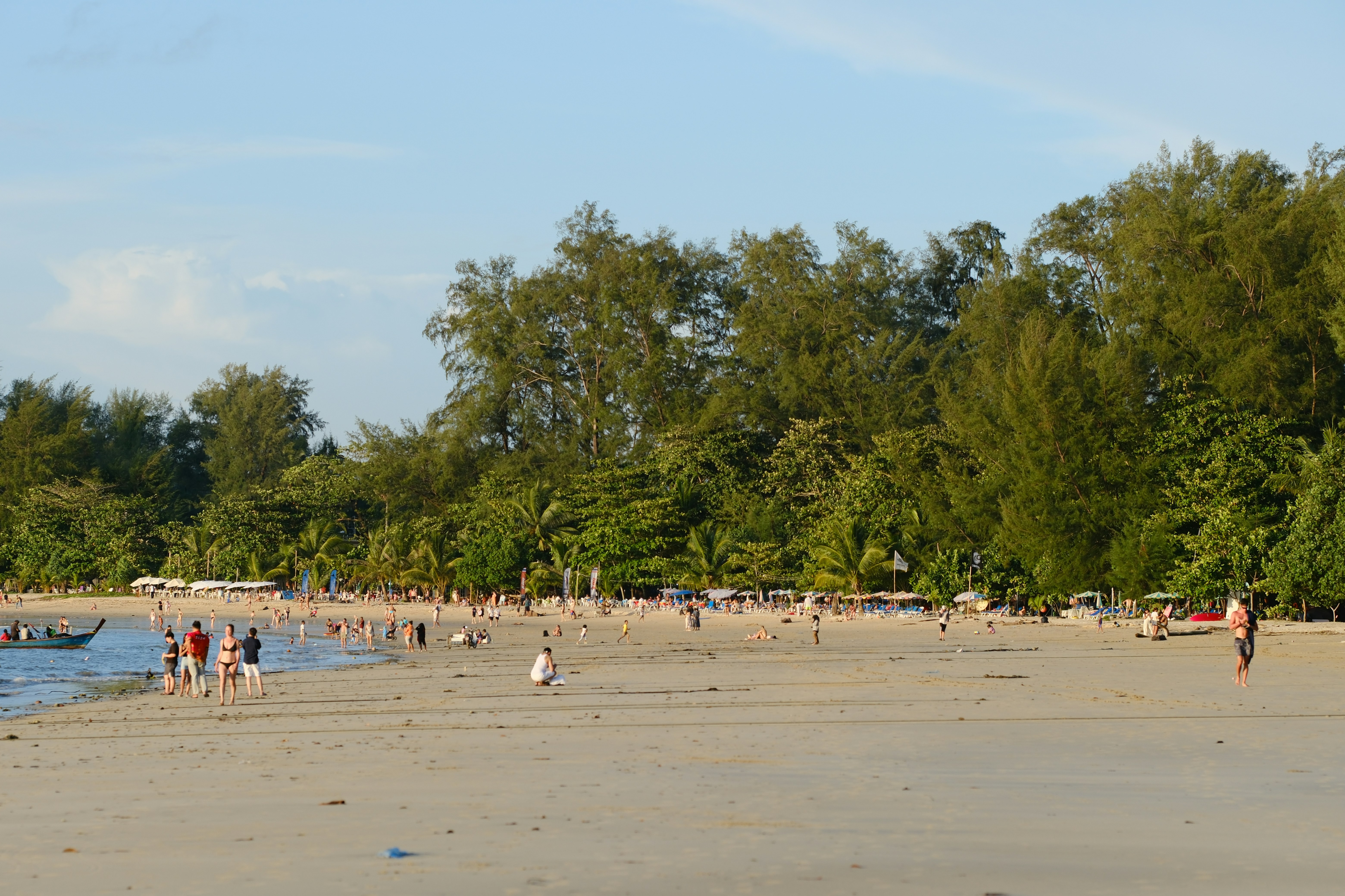 A group of people standing on top of a sandy beach