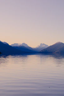 A body of water with mountains in the background