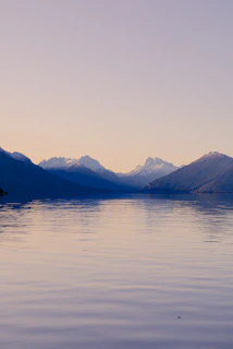 A body of water with mountains in the background