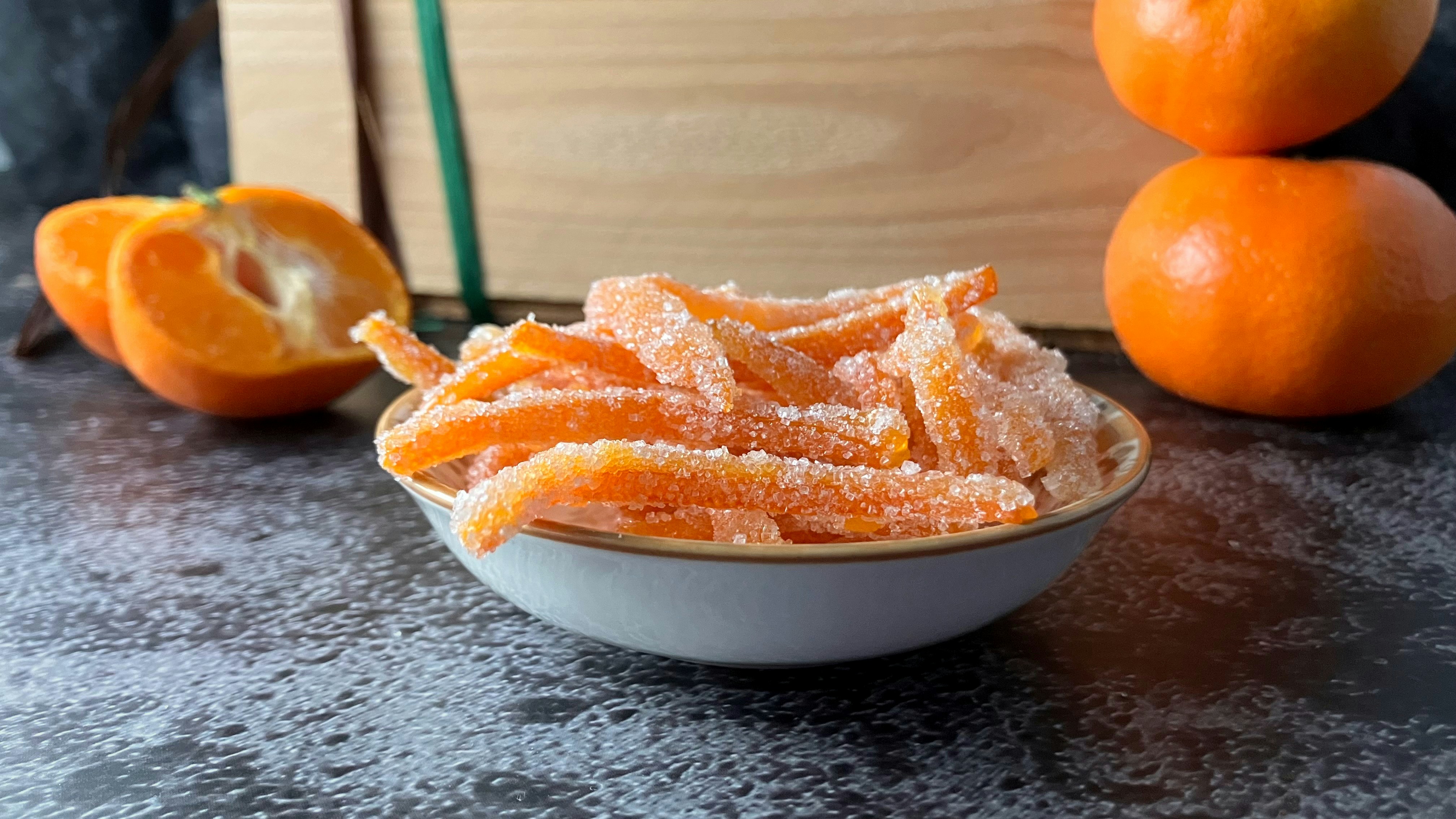 A bowl filled with orange peels next to a book