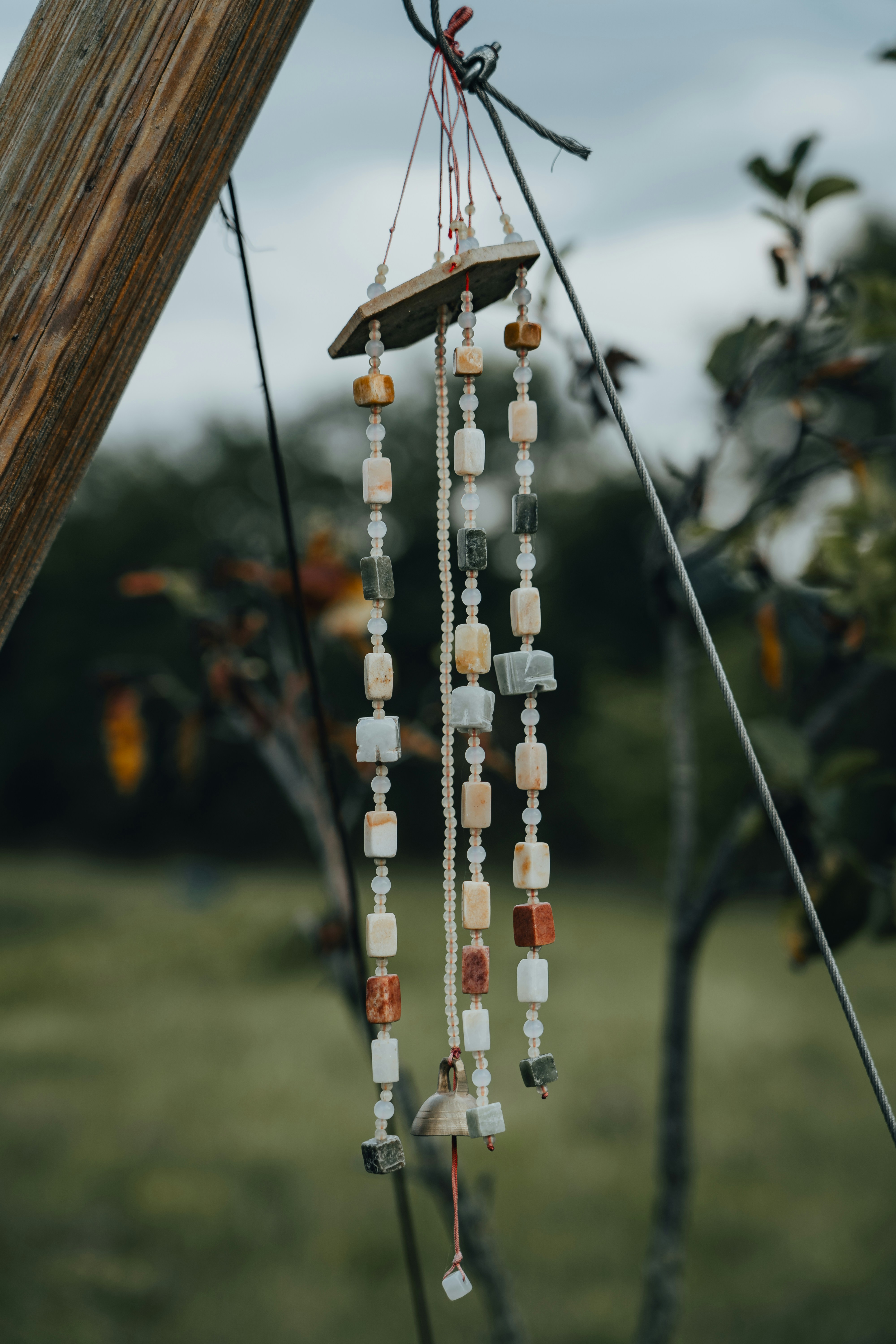 A wind chime hanging from a wooden pole