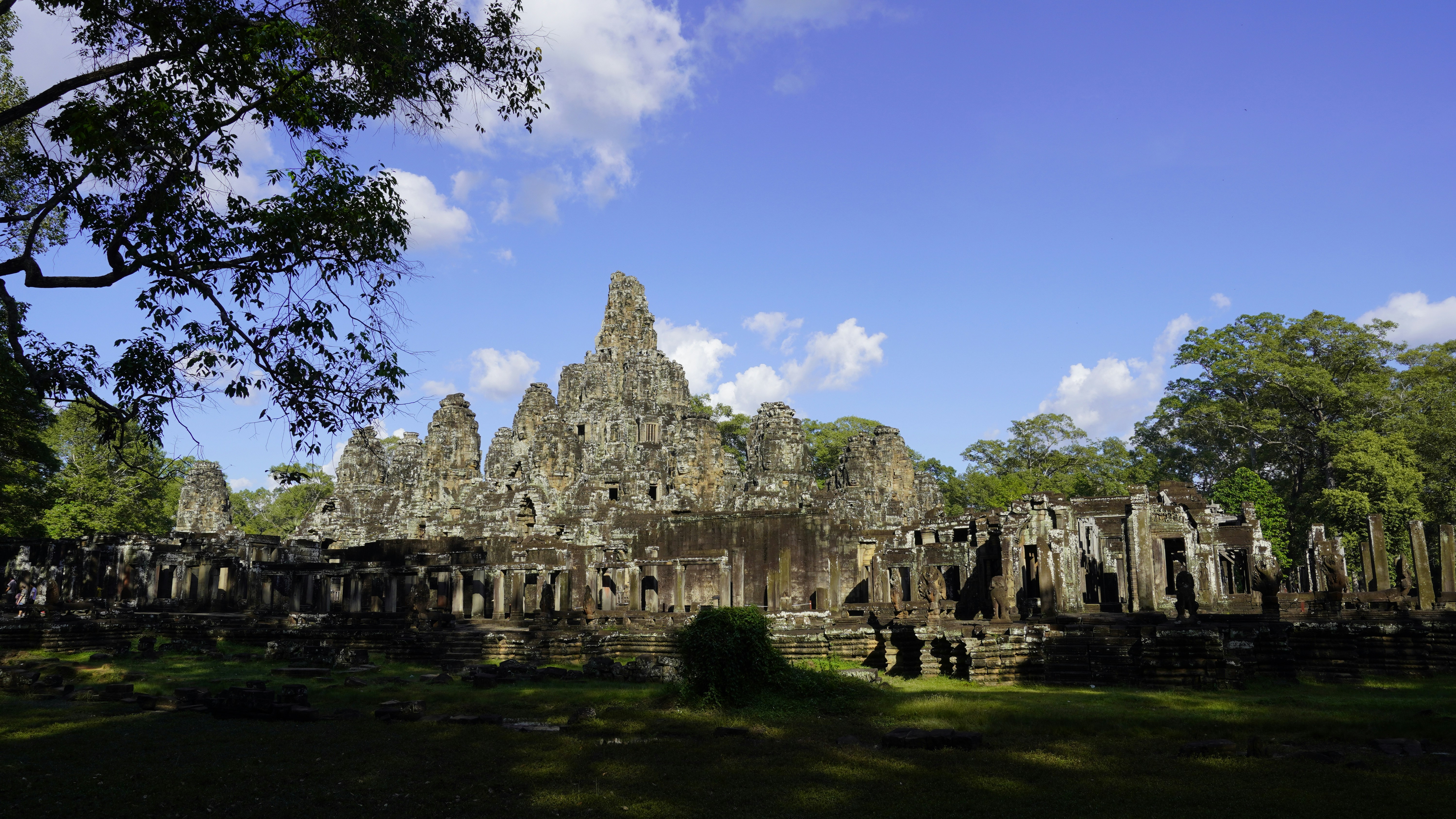 A picture of a tree in front of a building, Wide shot of Bayon Temple