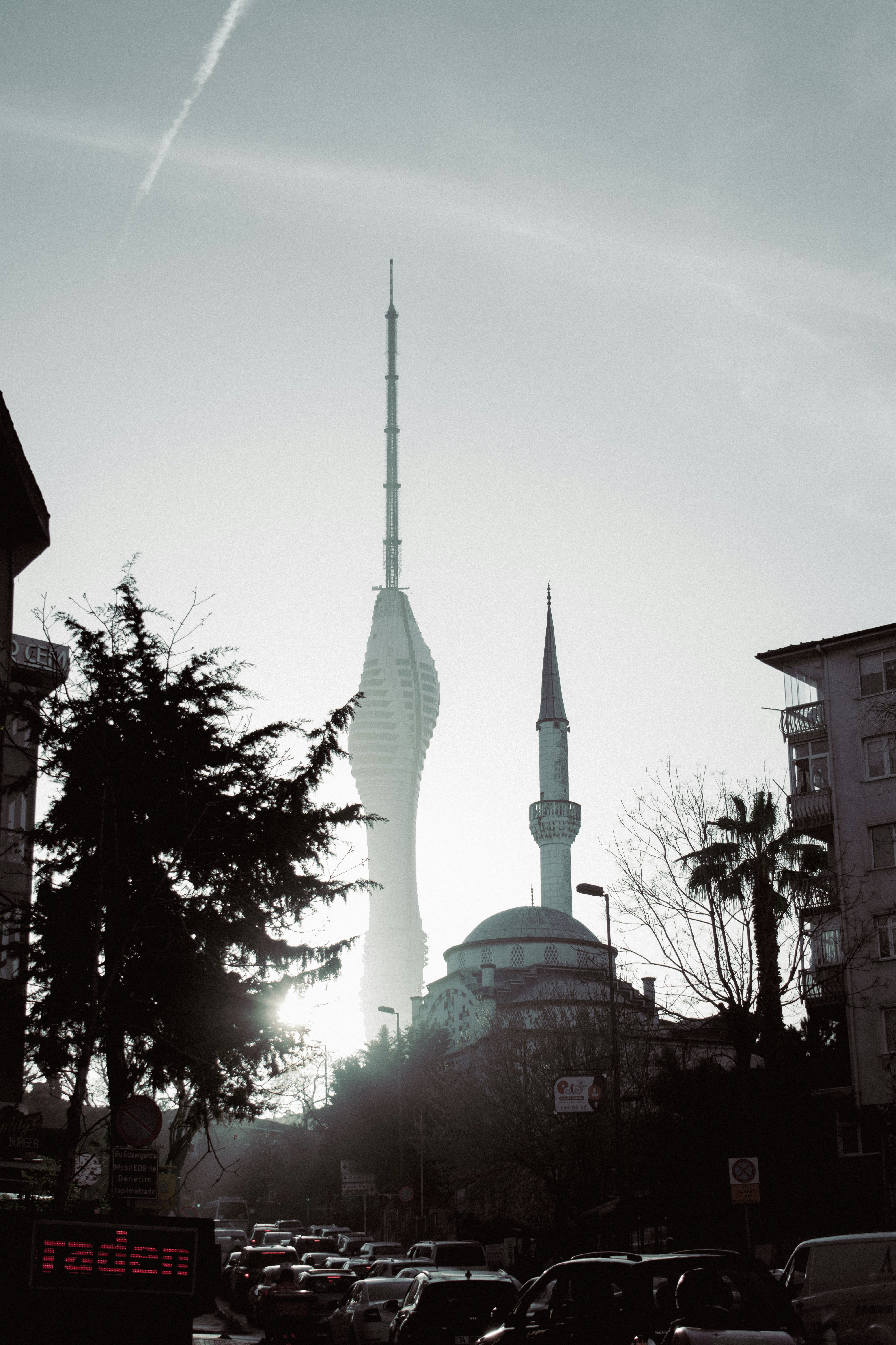 A city street filled with traffic next to tall buildings