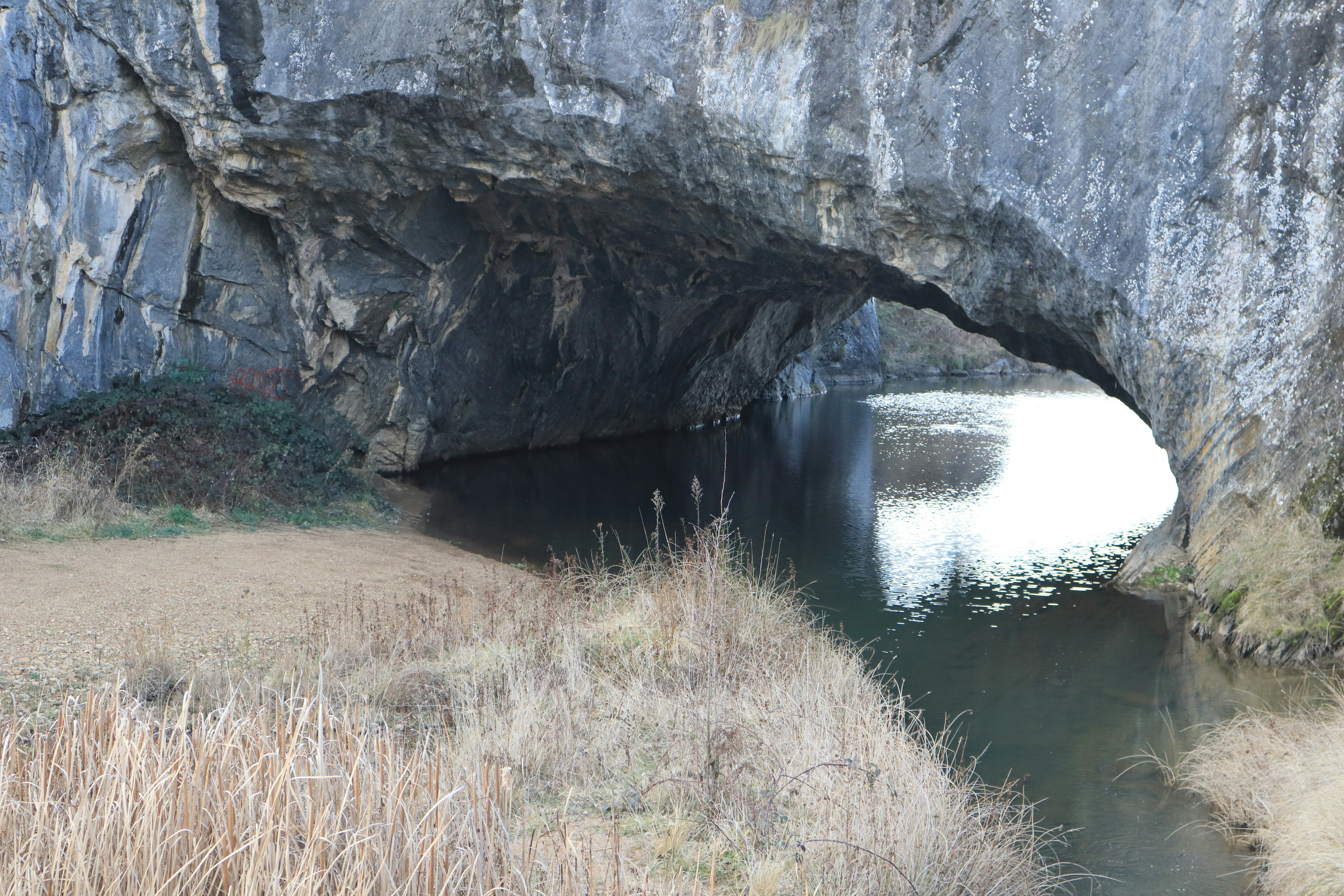 A large cave with a small stream running under it