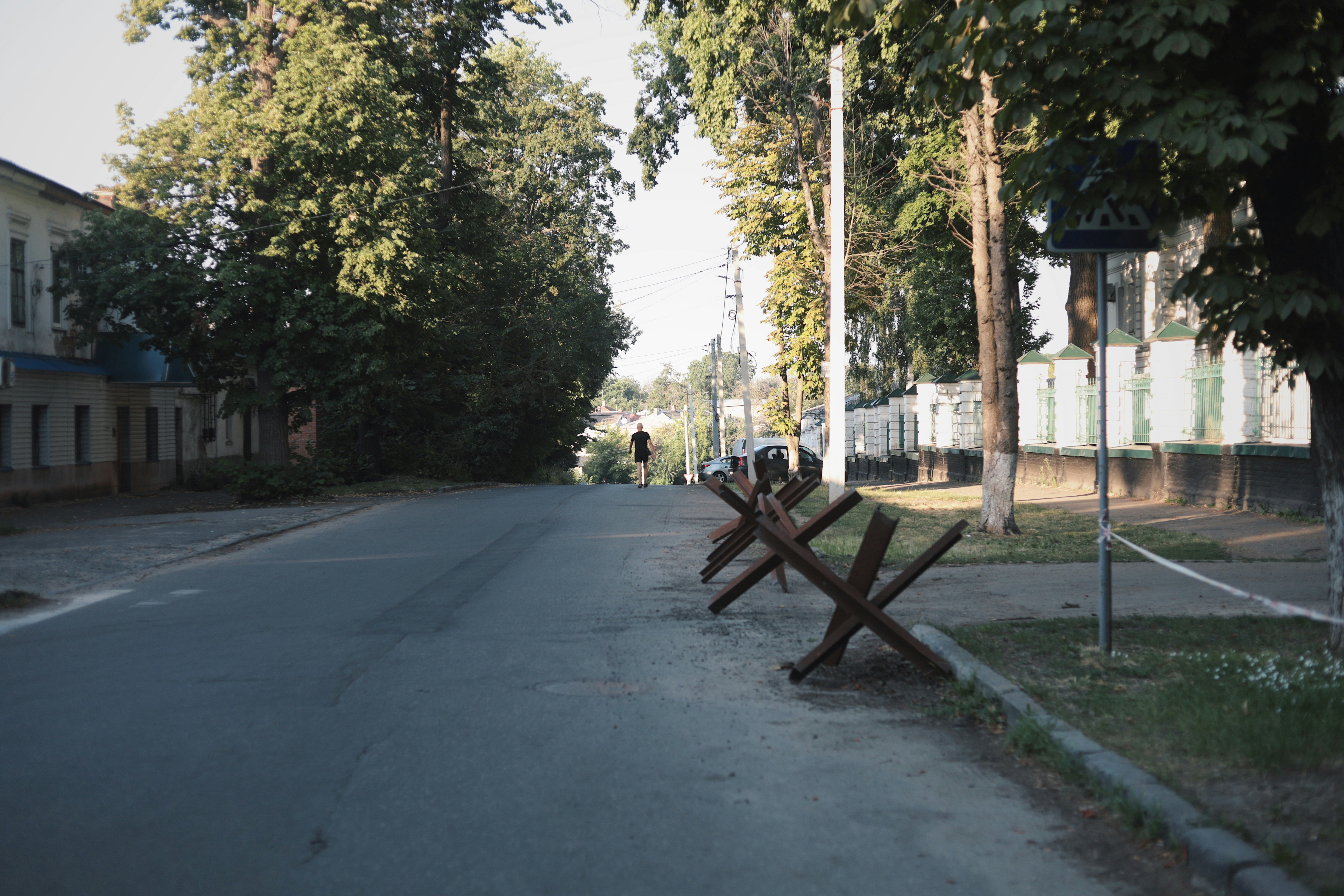A row of wooden benches sitting on the side of a road