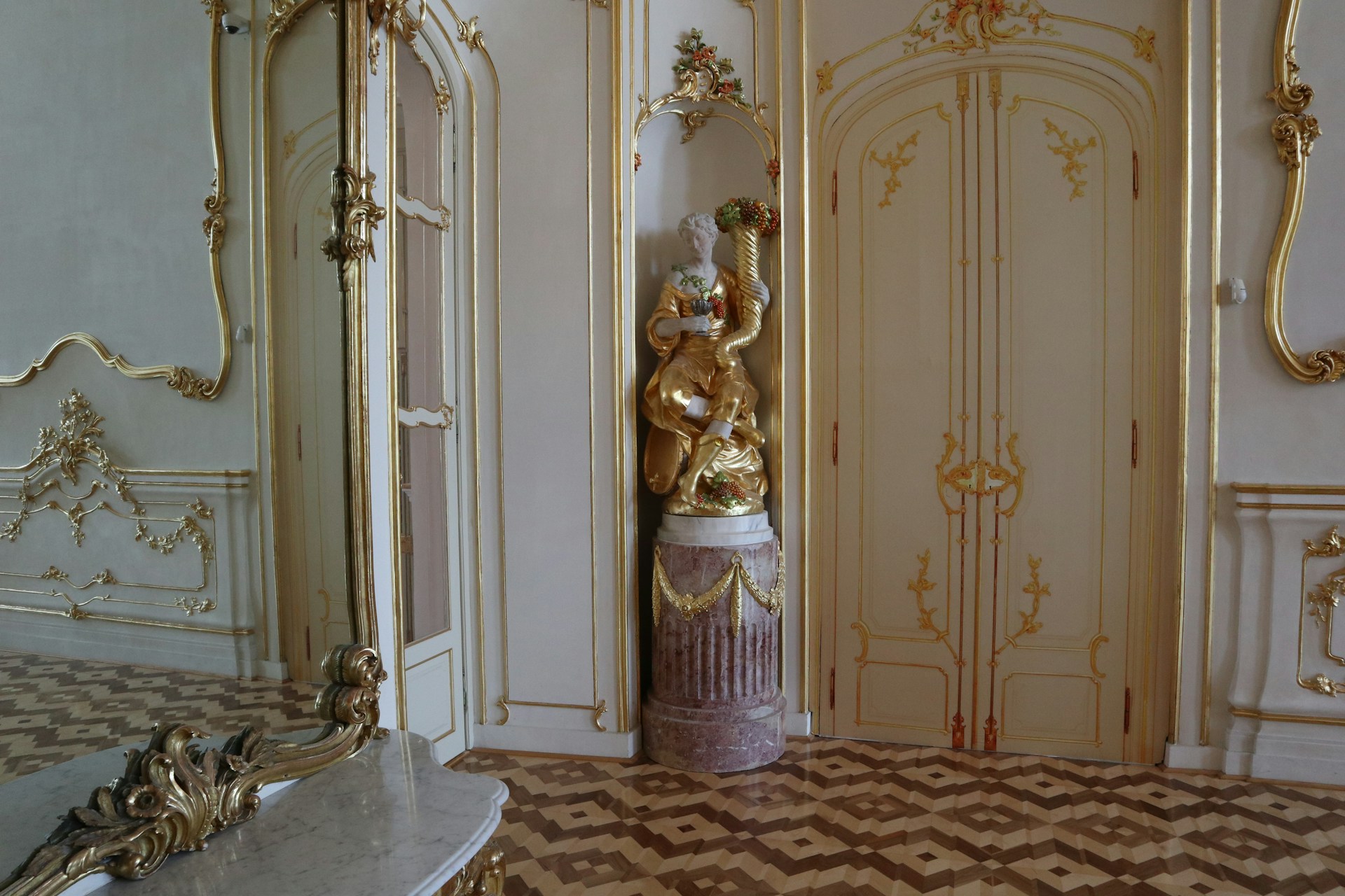 A room with a large mirror and a statue in it
