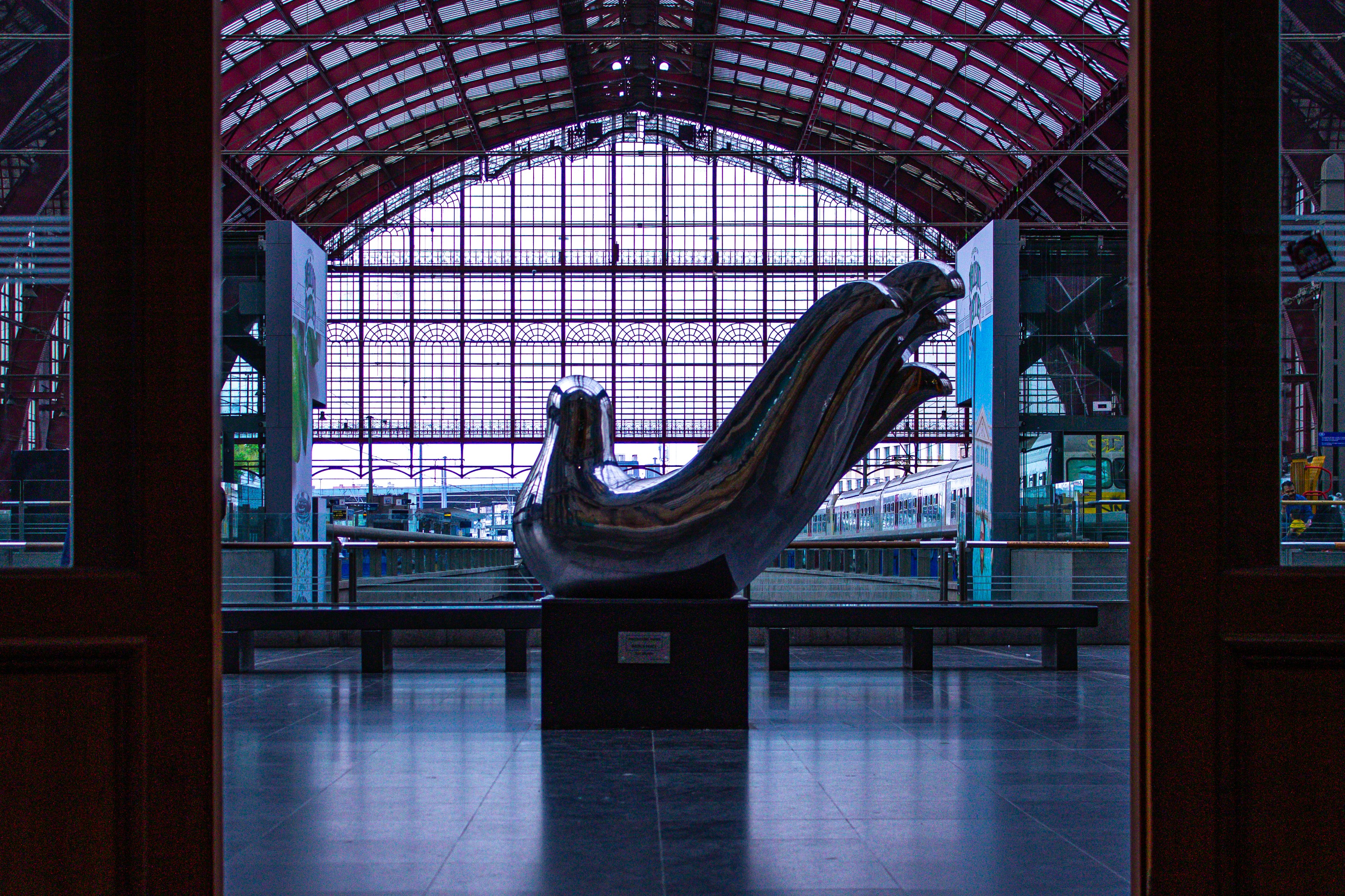A train station with a statue in the middle of it