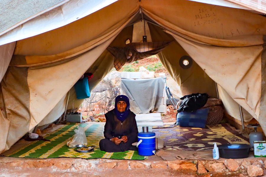 A person sitting inside a tent shelter