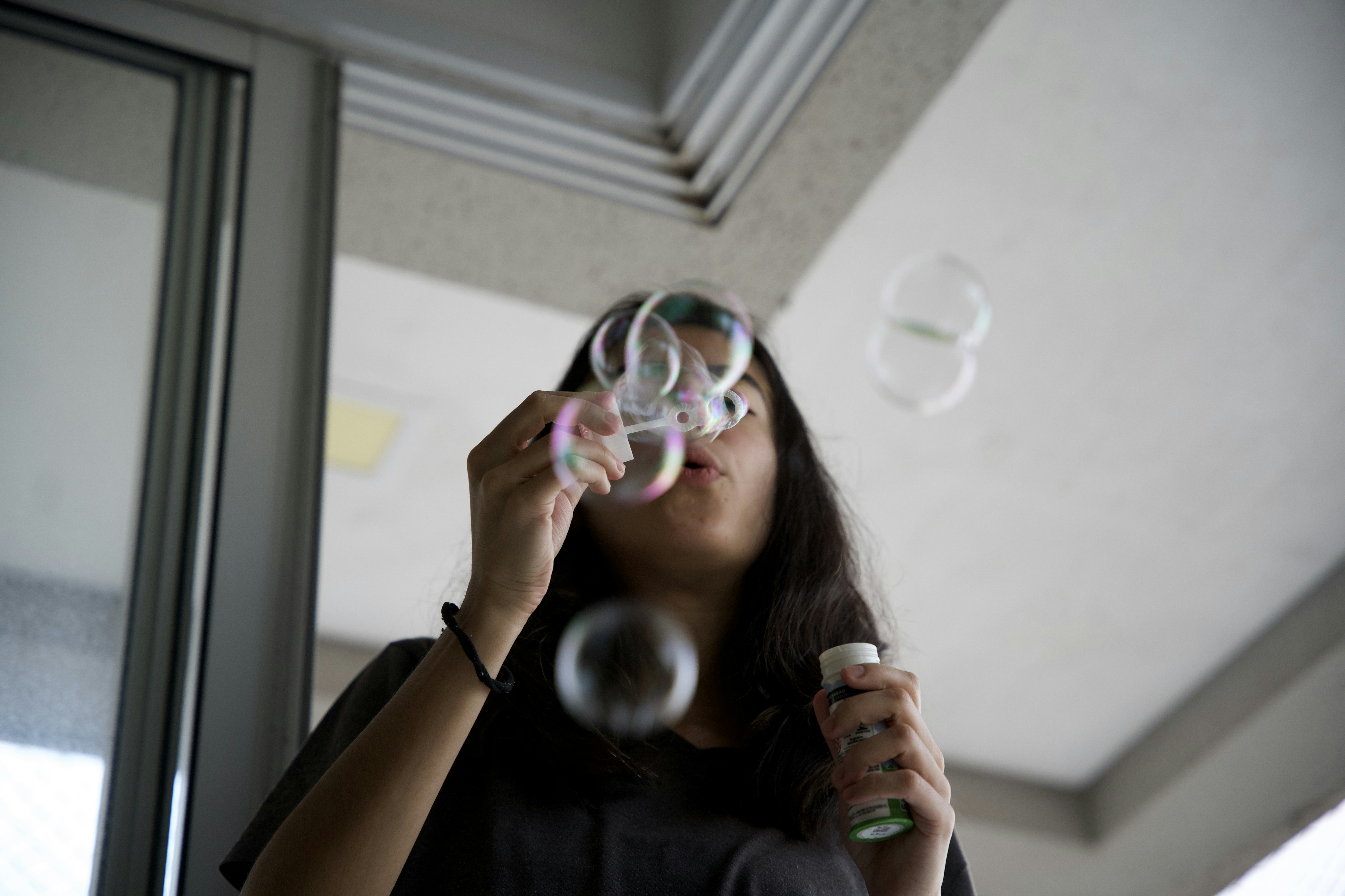 A woman blowing bubbles in a room