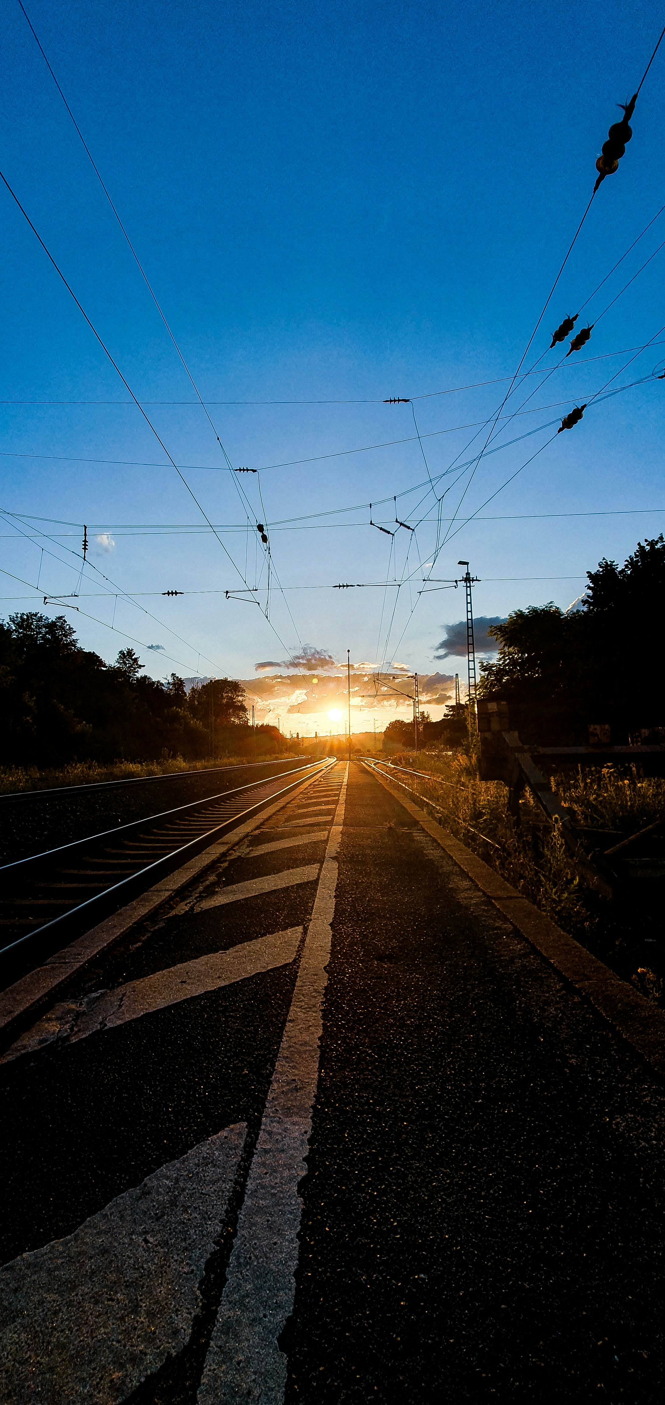 A train track with the sun setting in the background