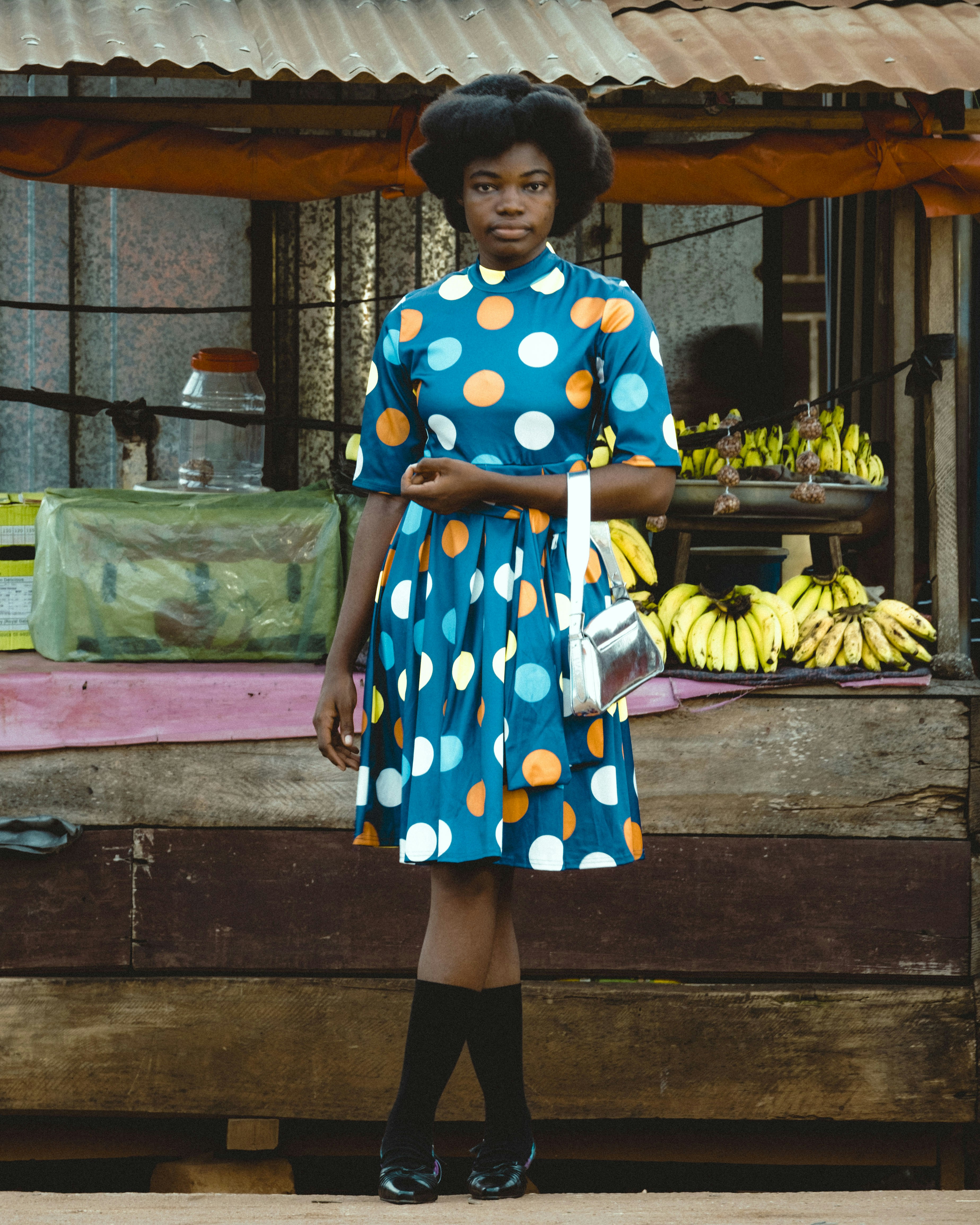 A woman standing in front of a fruit stand
