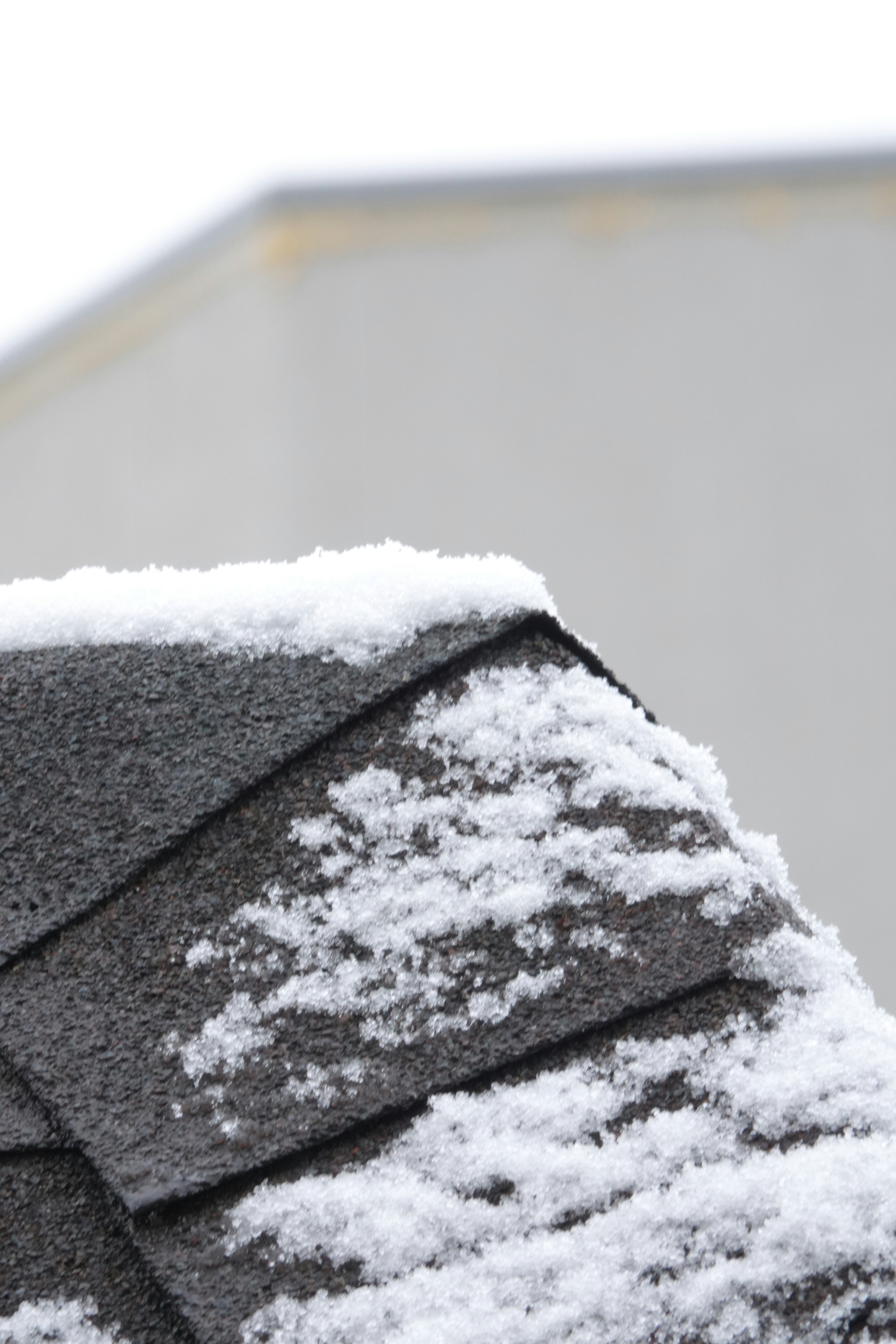 The roof of a house is covered in snow