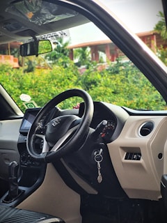 The interior of a car with a steering wheel and dashboard