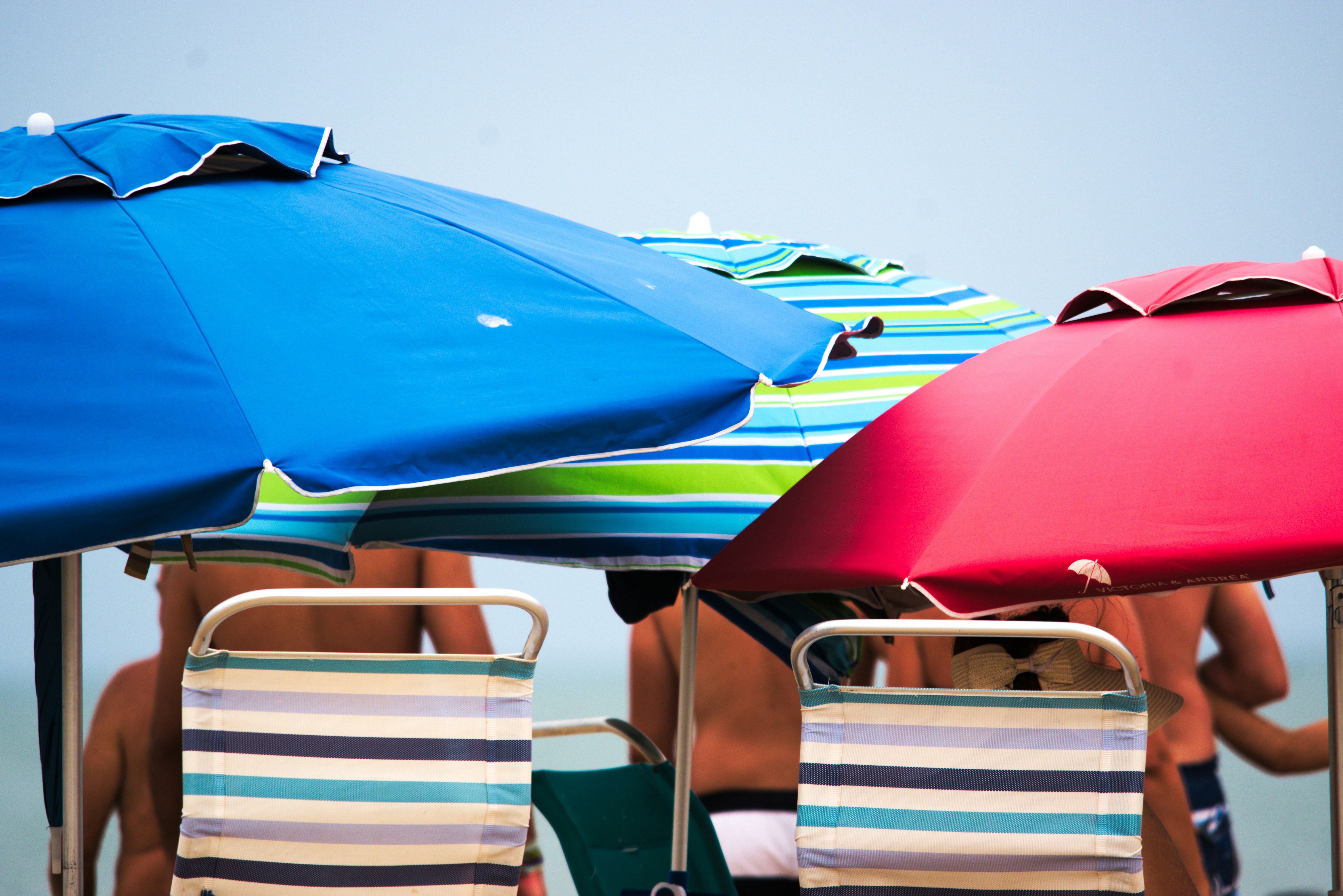 Colorful beach accessories laid on white sand, bright sunny day, tropical beach setting