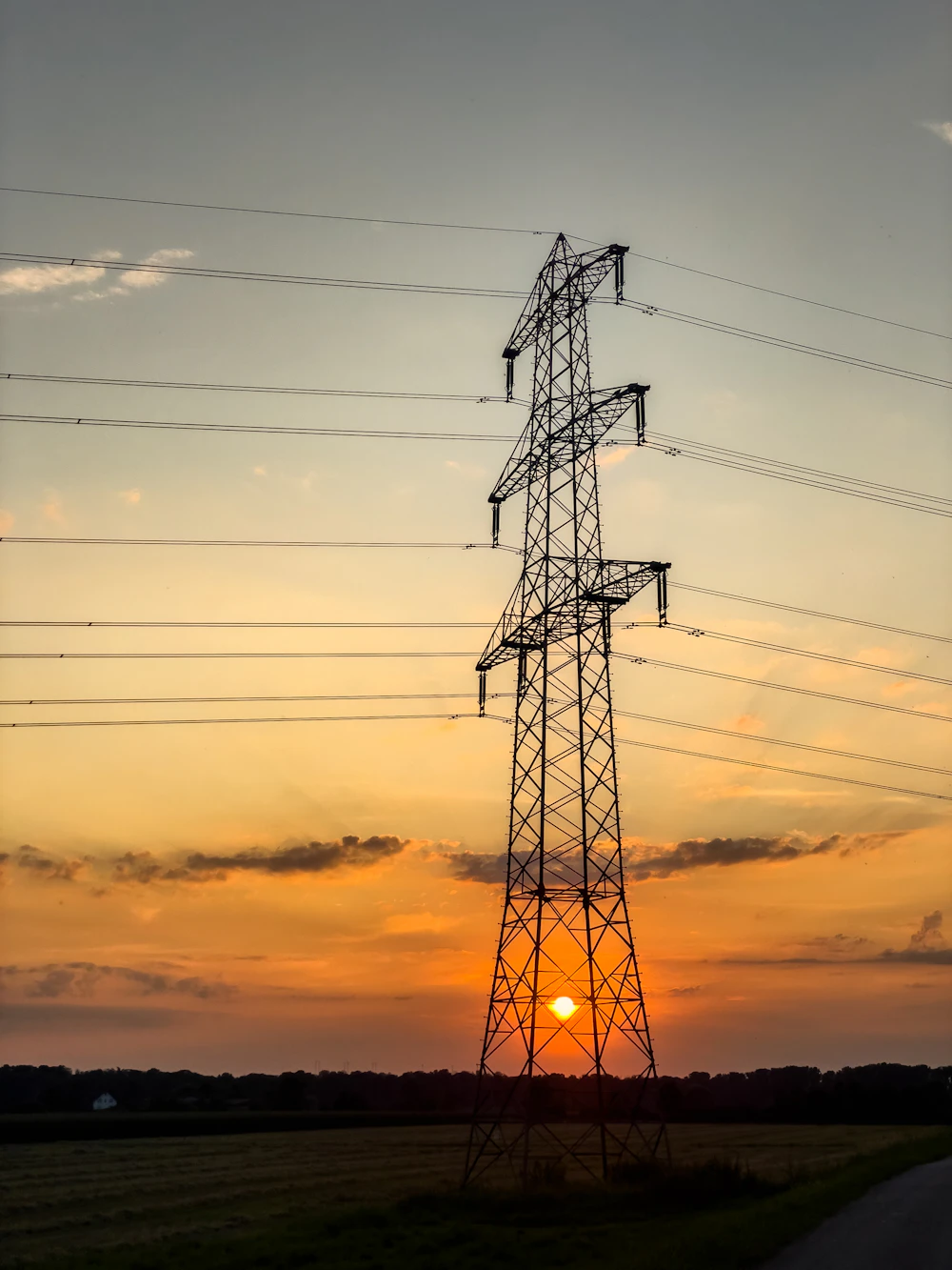 Power lines at sunset, representing electrical infrastructure maintenance in desert conditions in Abu Dhabi