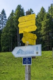 A wooden pole with a bunch of signs on top of it