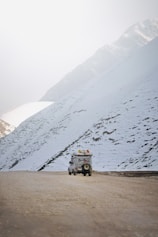 A truck driving down a snow covered road