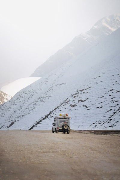 A truck driving down a snow covered road