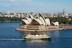 A boat in a body of water near a large building