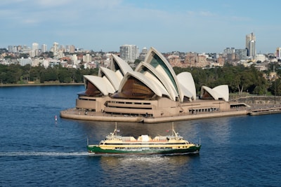 A boat in a body of water near a large building