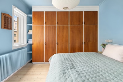 A bedroom with blue walls and a white bed