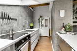 A kitchen with a sink a stove and a refrigerator