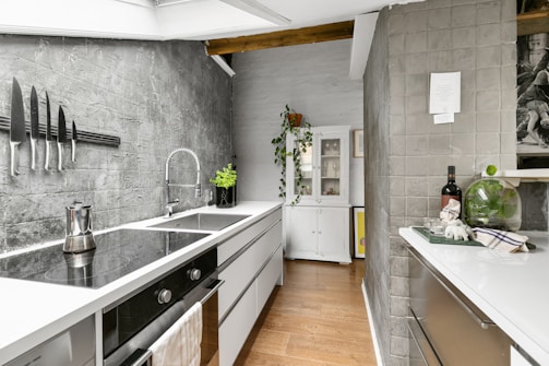 A kitchen with a sink a stove and a refrigerator