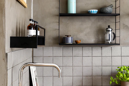 A kitchen with a sink and shelves above it