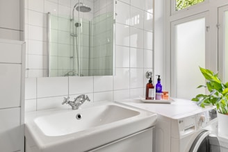 A washer and dryer in a white bathroom