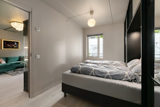 A bedroom with a large bed and a green couch