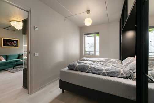 A bedroom with a large bed and a green couch