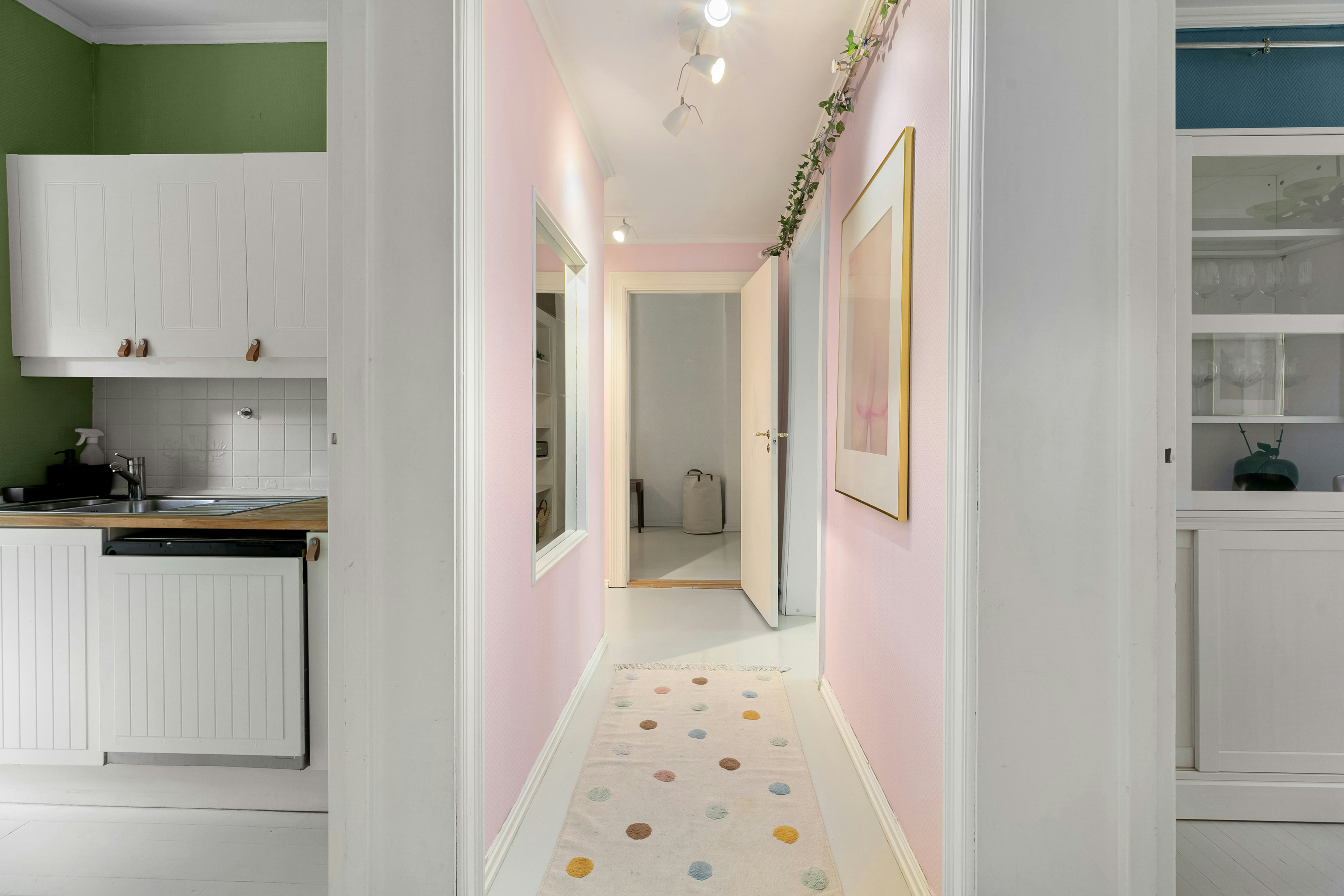 A hallway leading to a kitchen with green walls