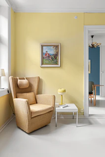A living room with yellow walls and a chair