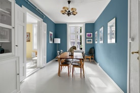 A dining room with blue walls and white floors