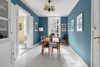A dining room with blue walls and white floors