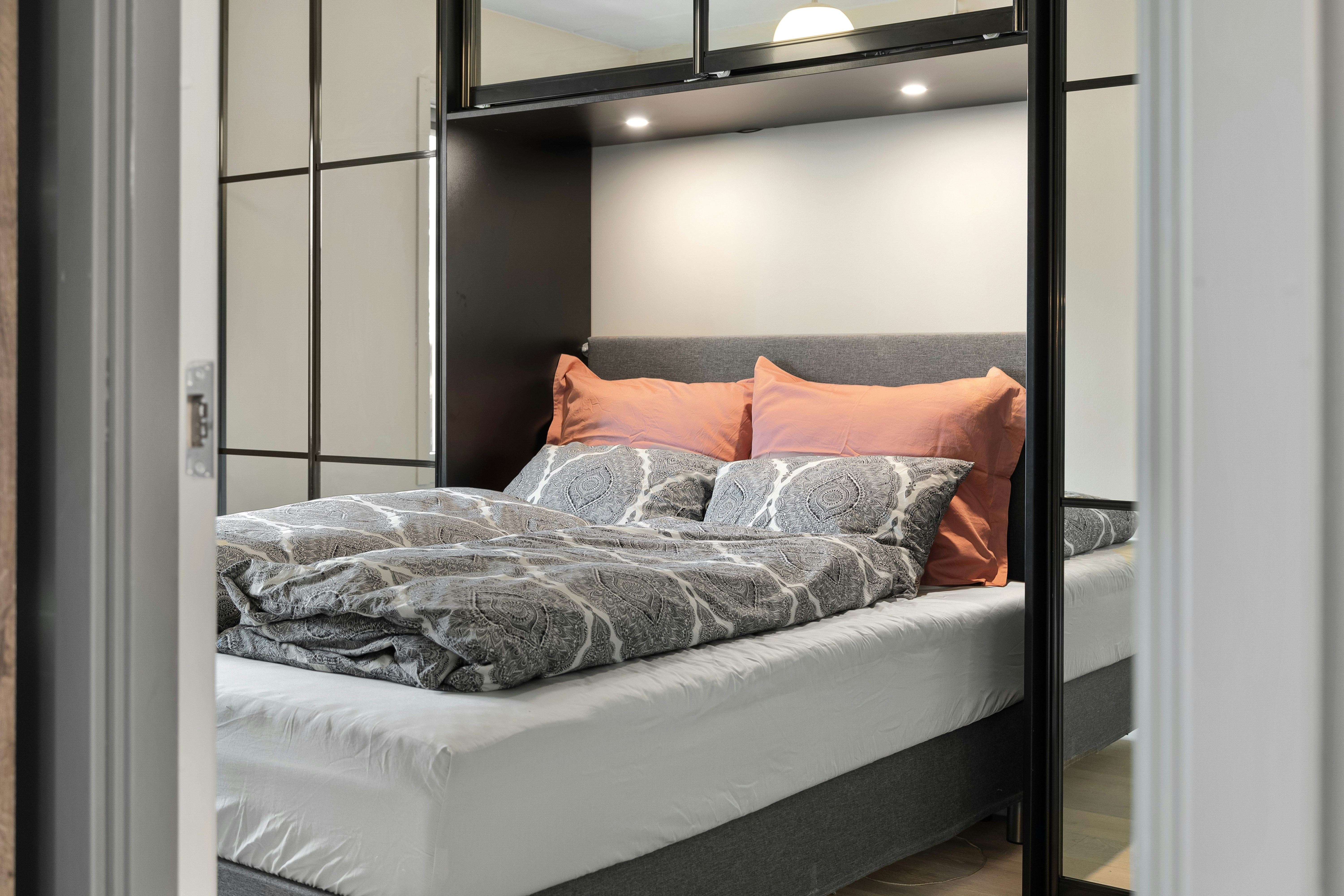 A bed sitting in a bedroom next to a mirror