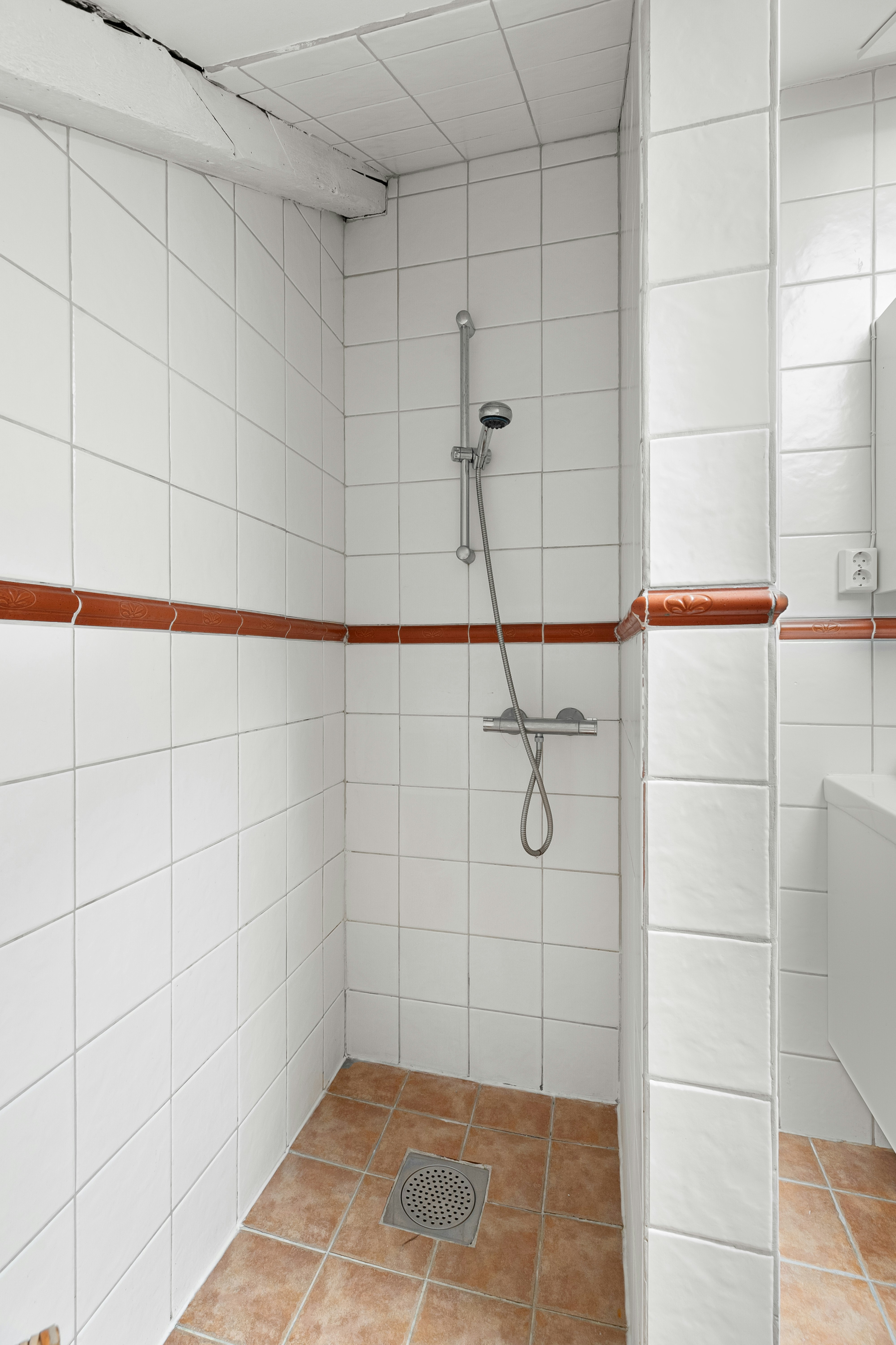 A bathroom with a shower, sink and mirror