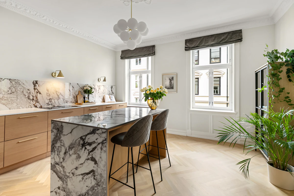 Renovated kitchen with marble countertops and warm wooden cabinetry