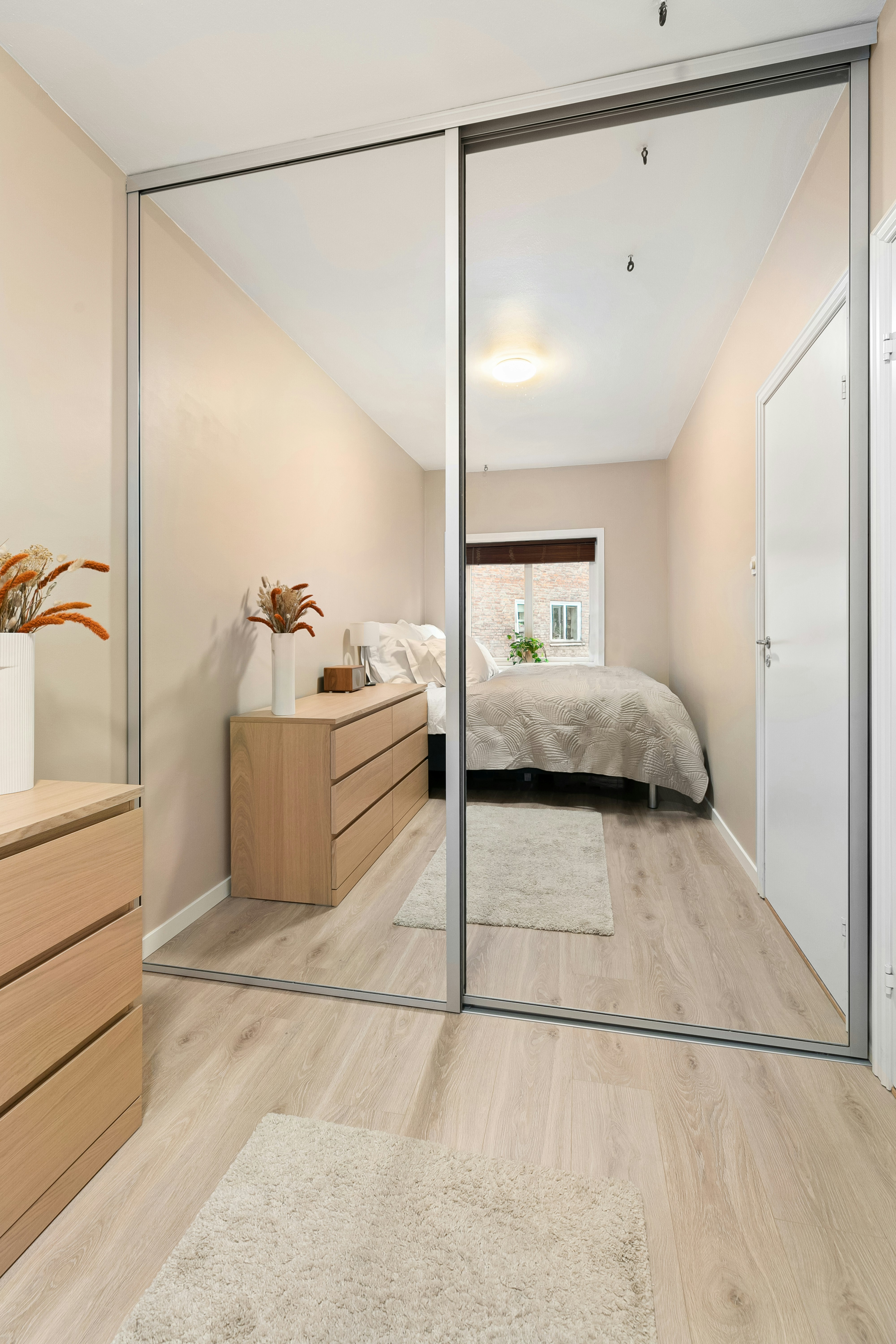 A bedroom with a mirrored closet door and a bed