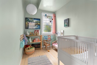 A baby's room with a white crib and wooden floors