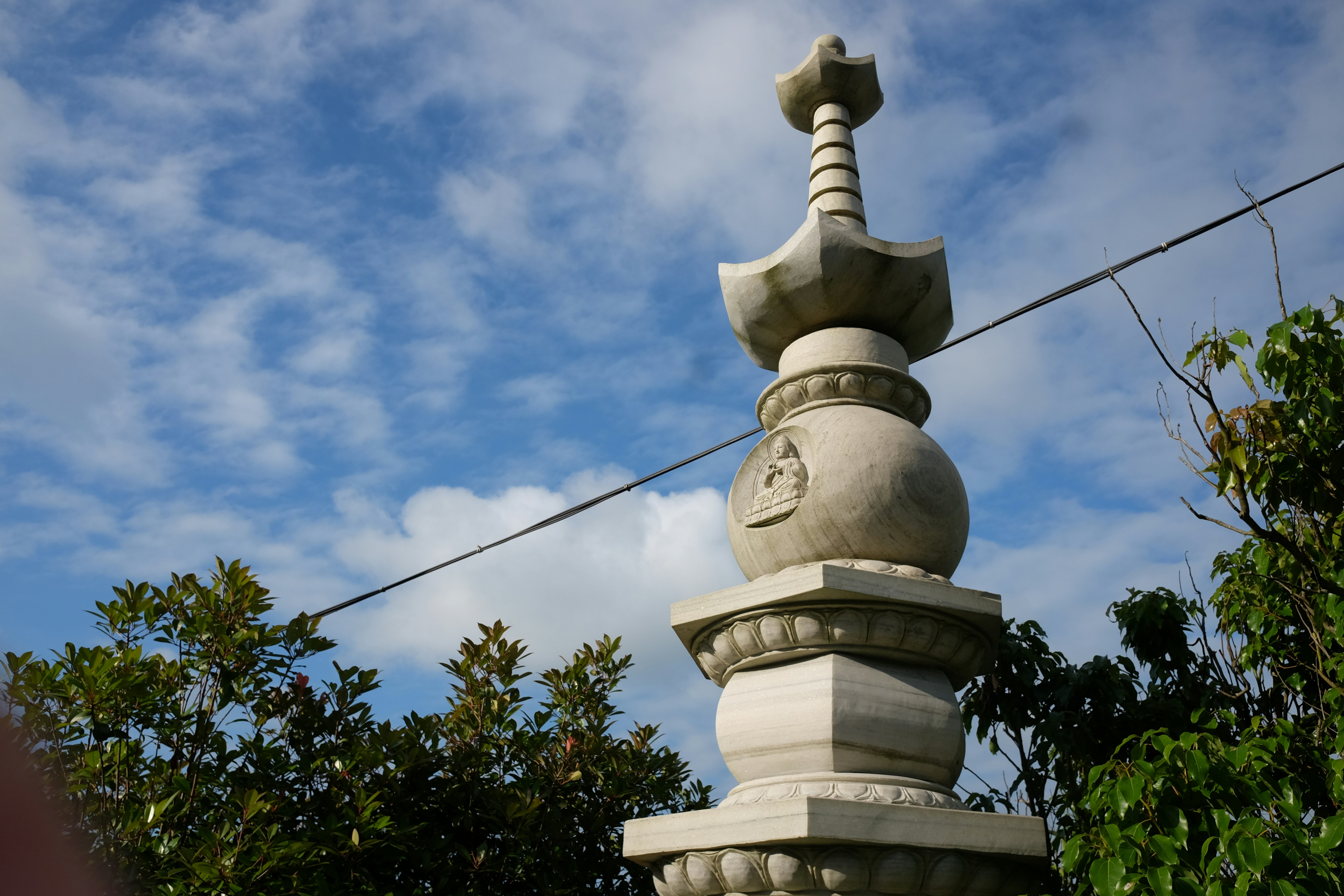 A stone statue with a bird on top of it