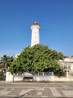 A tall white tower with a cross on top of it