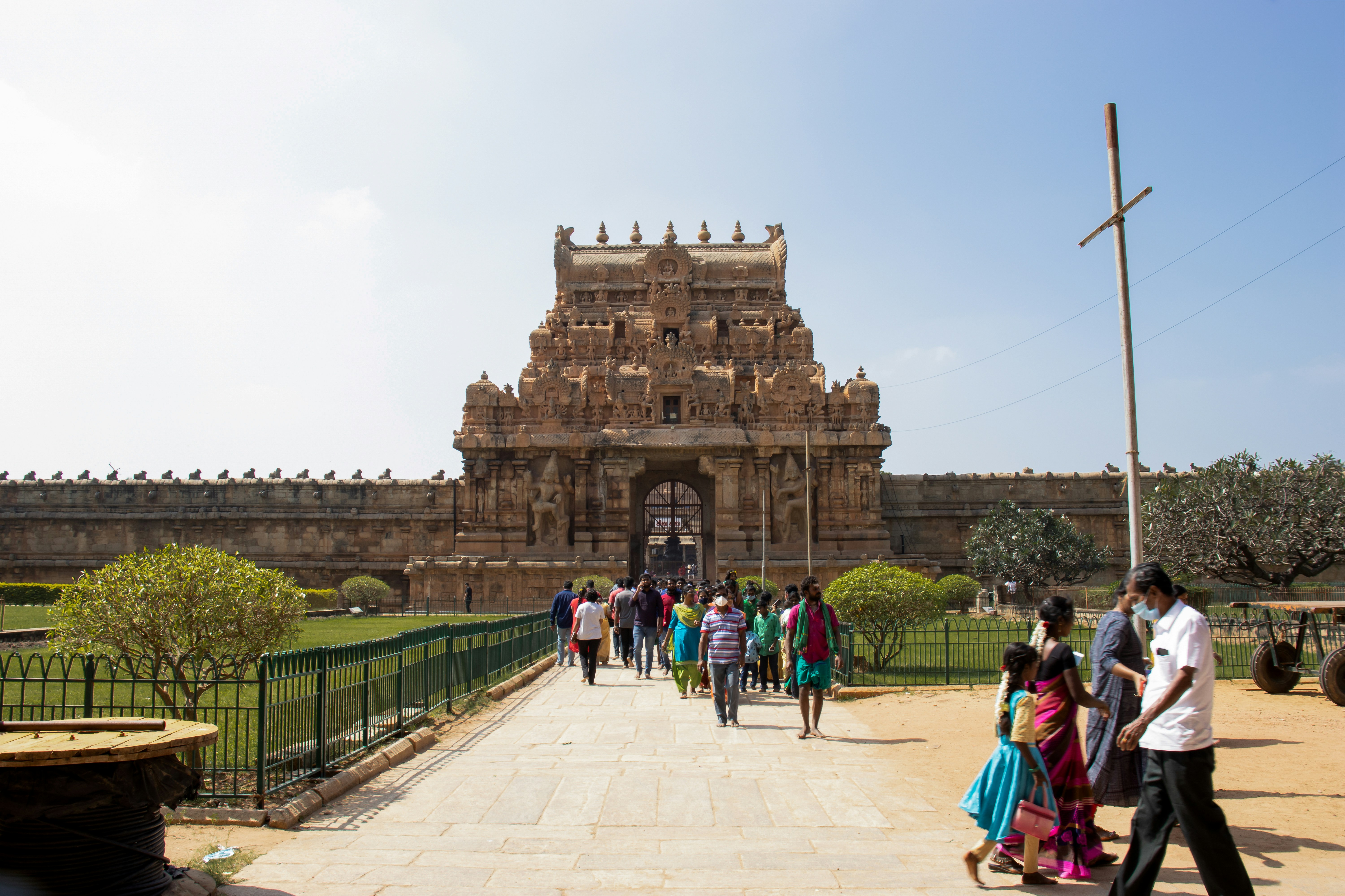 A group of people walking down a walkway in front of a building