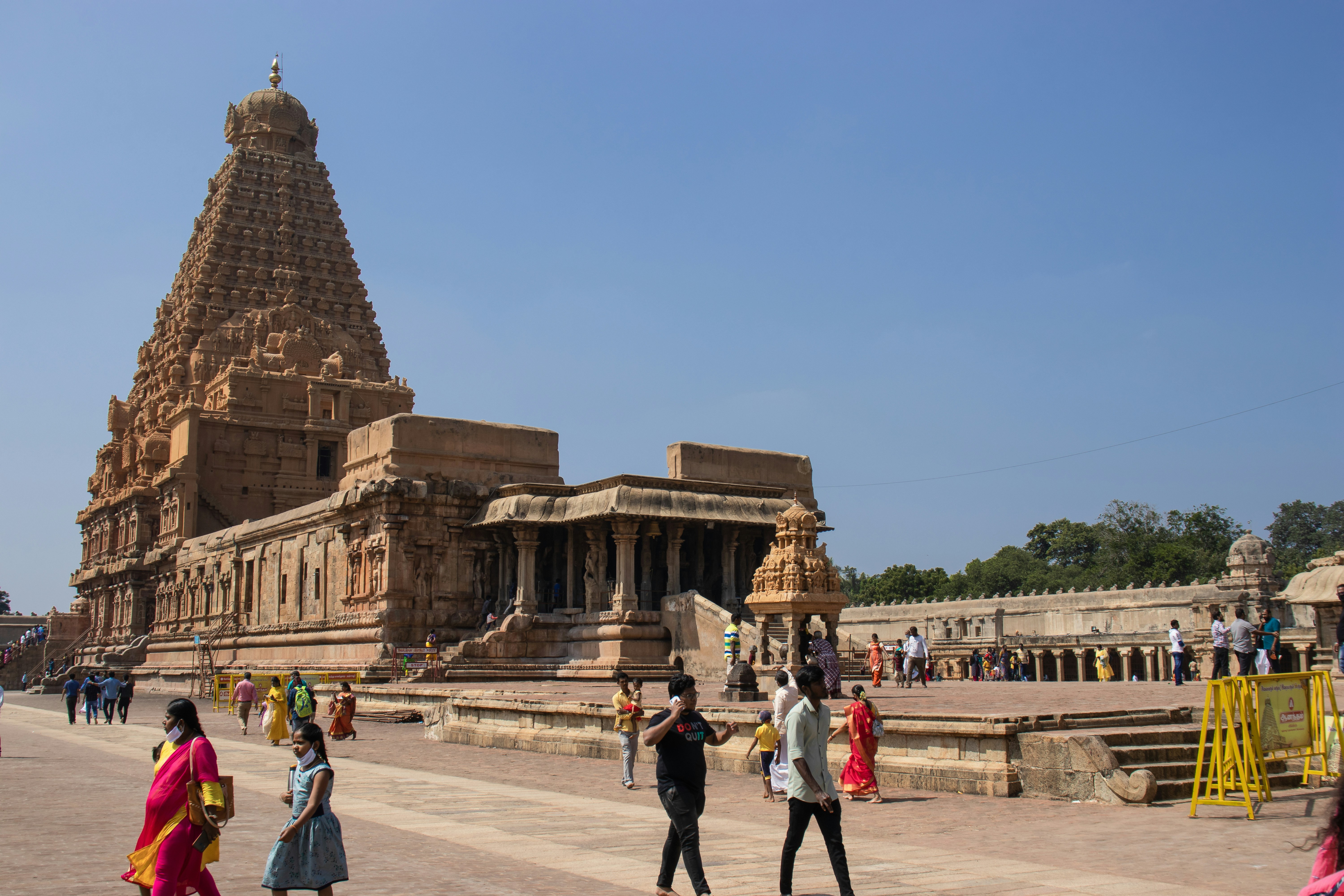 A group of people walking around a stone structure