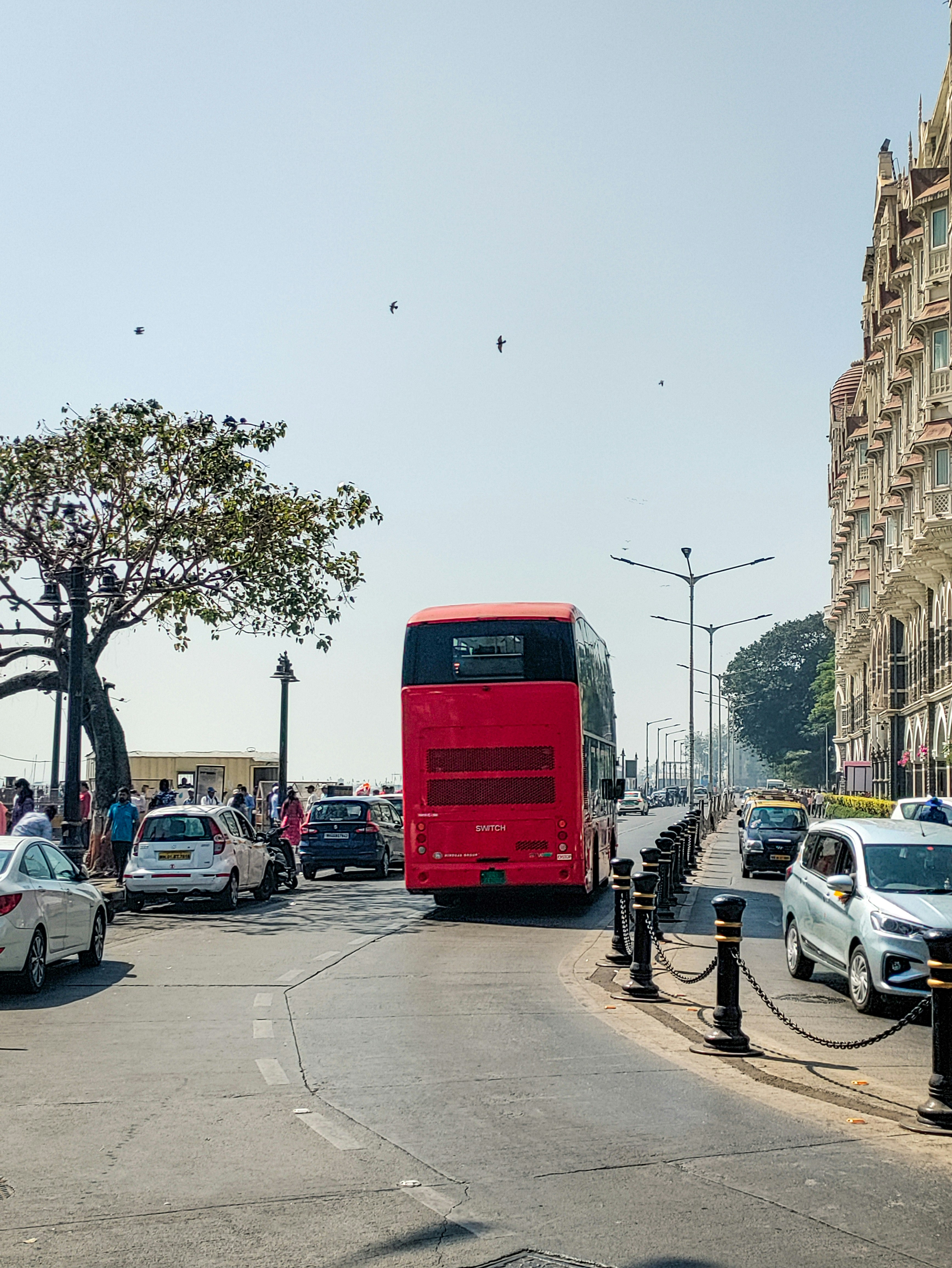 A red double decker bus driving down a street