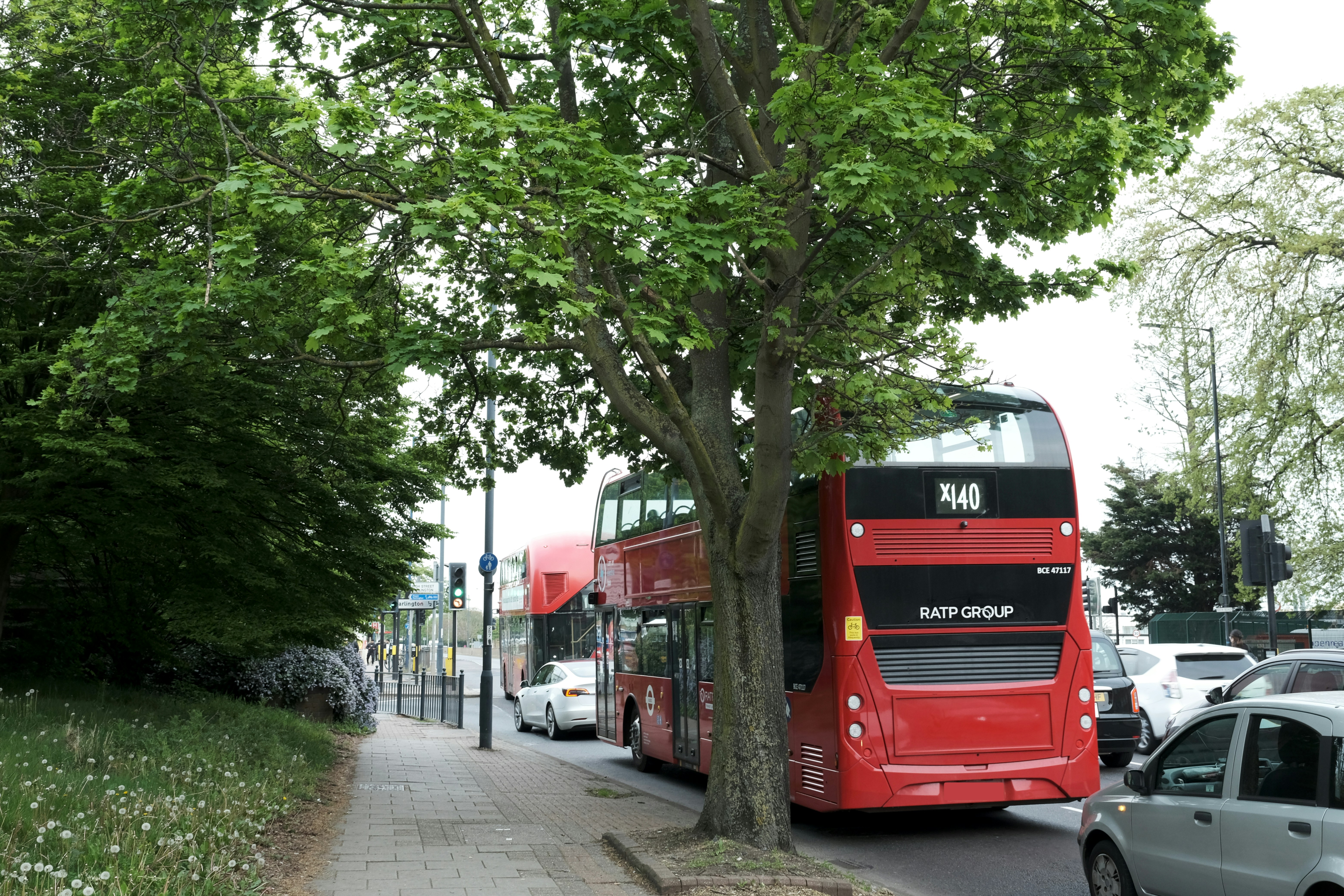 A red double decker bus driving down a street
