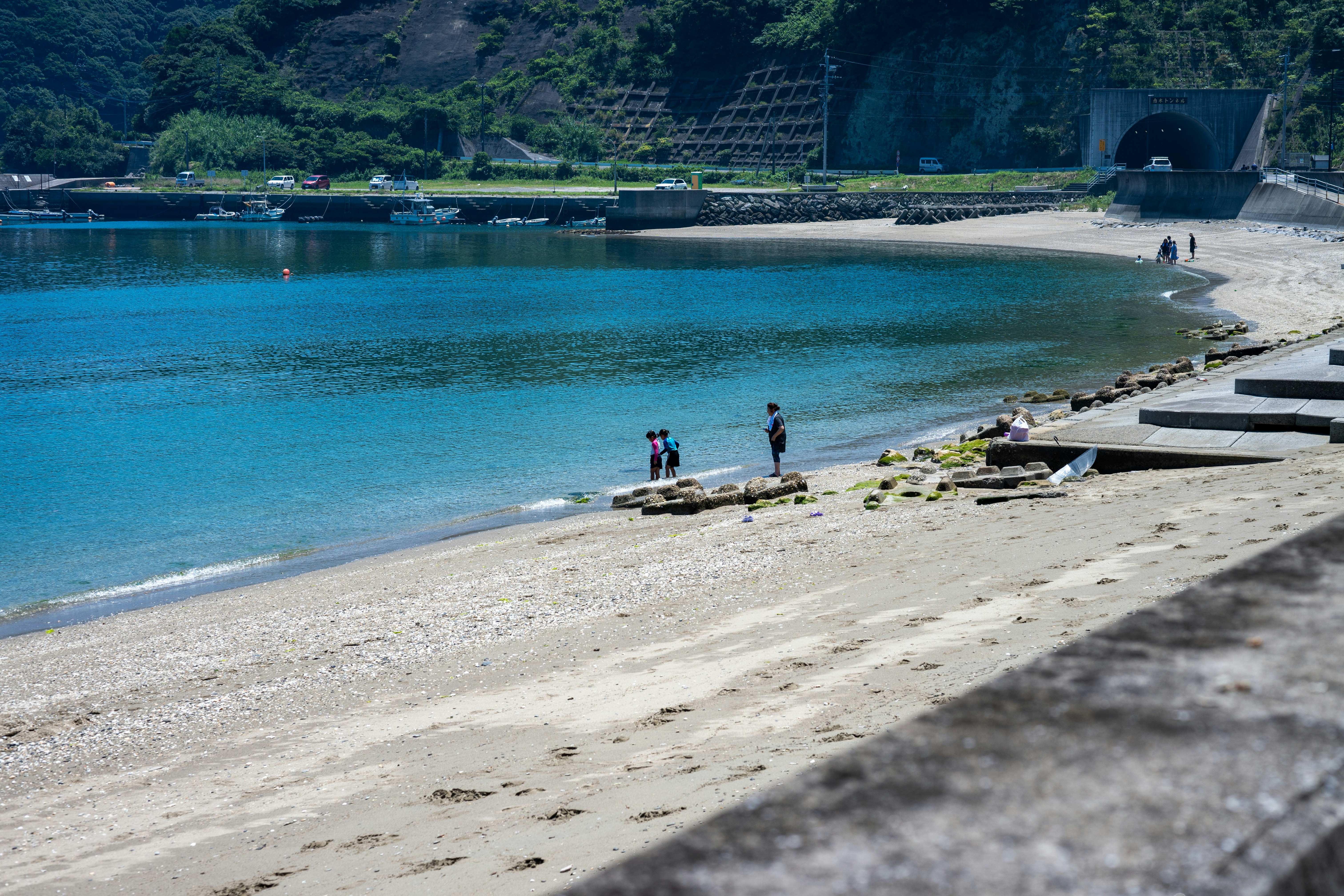 A group of people standing on top of a sandy beach