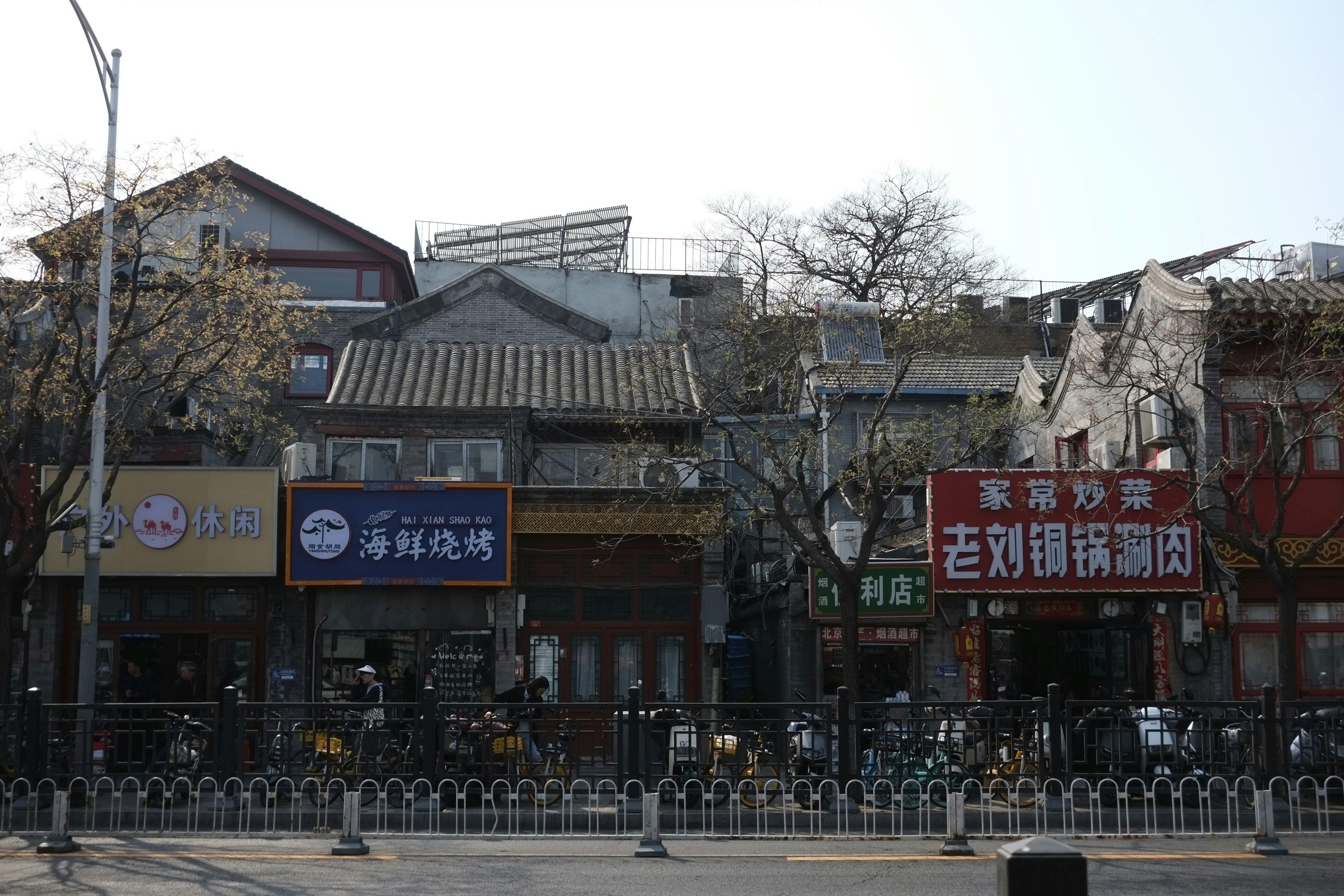 A city street with buildings and a fence