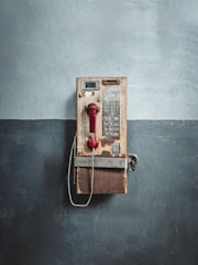 An old phone is hanging on a wall