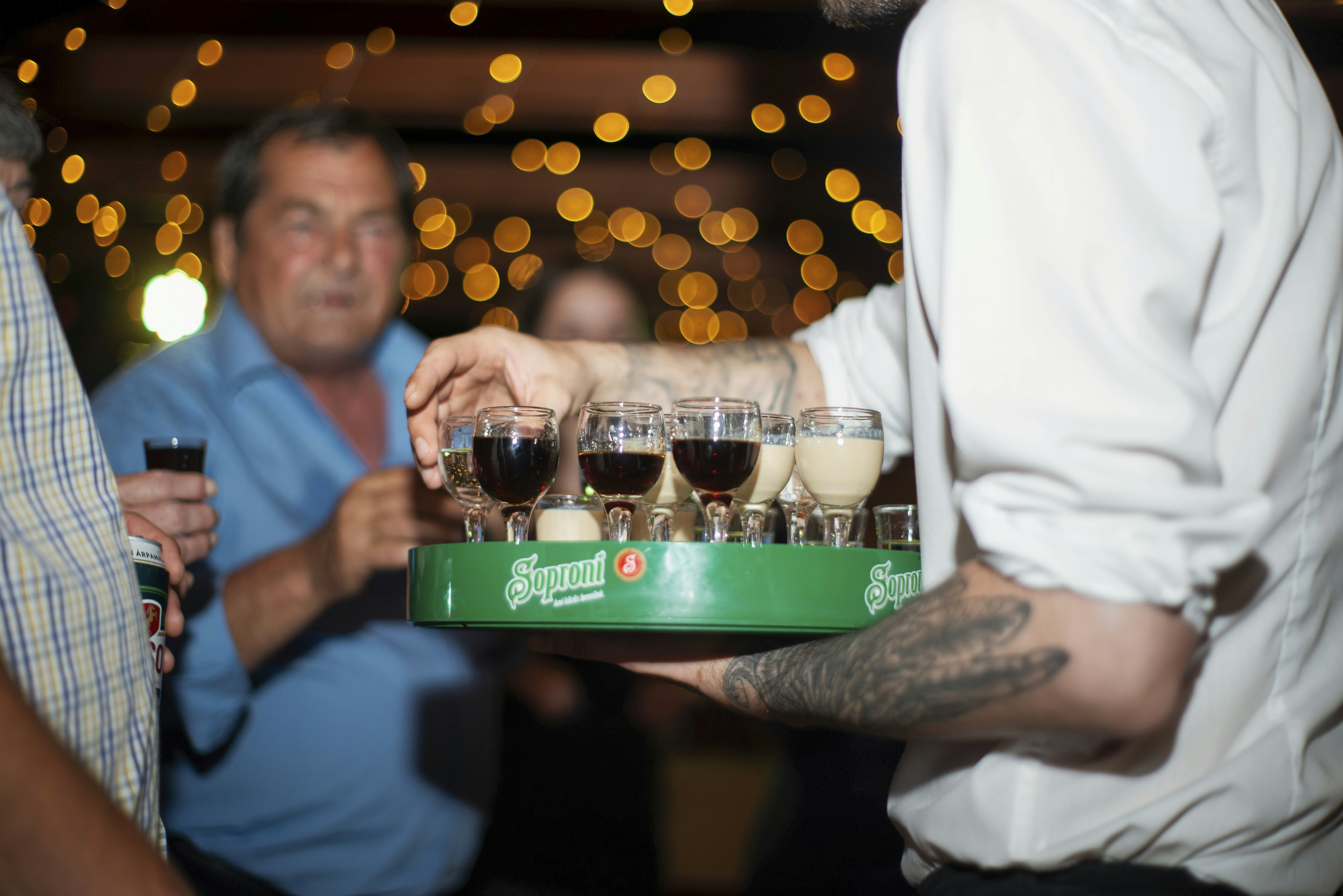 A man holding a tray of wine glasses